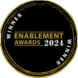 Black circular badge with gold and white text reading "Enablement Awards 2024" and "Winner" repeated around the edge.