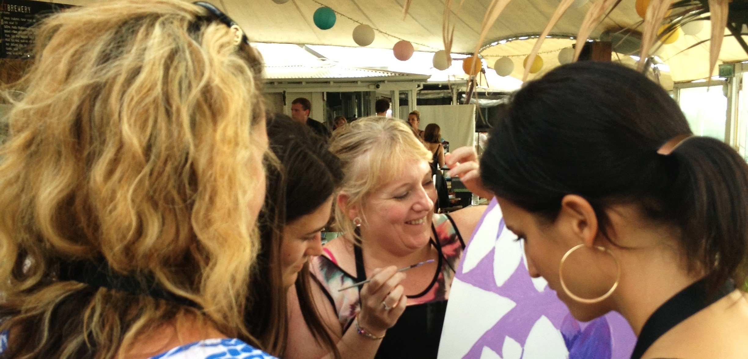 Corporate teams creating collaborative artwork during a large Team Mural workshop