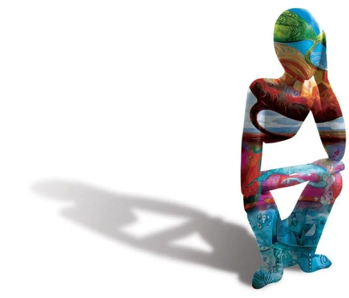 Colorful cutout silhouette of a woman squatting with arms resting on knees, casting a shadow on a white background.