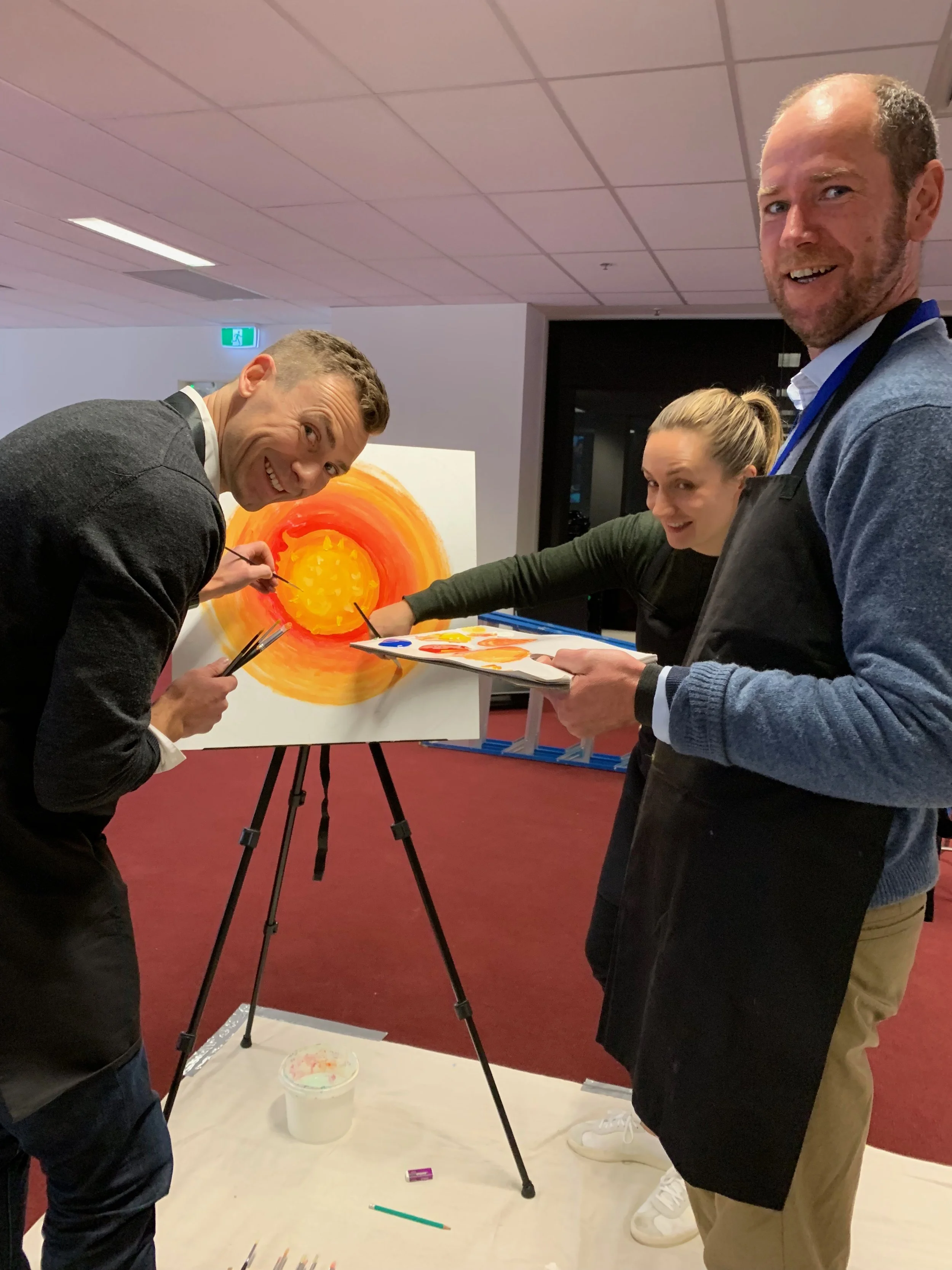 Corporate team creating a collaborative team mural during a team building workshop