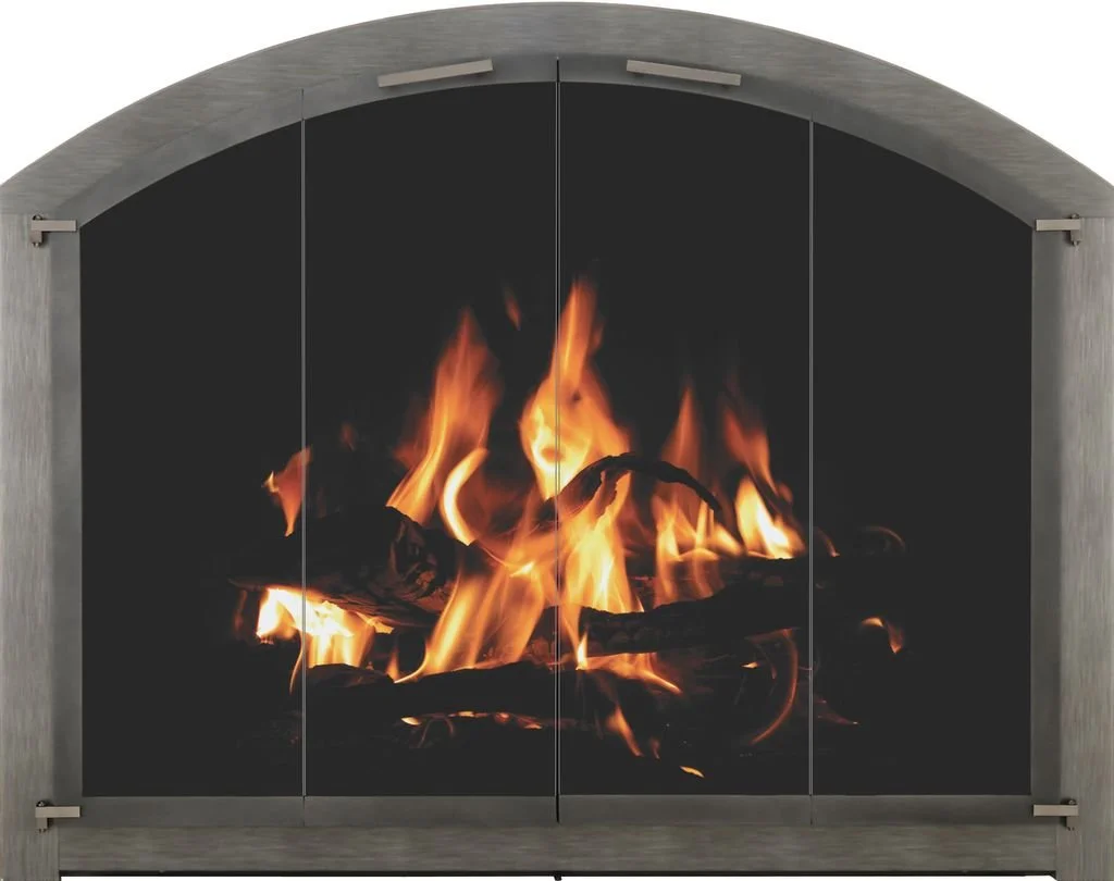 A modern fireplace with a fire burning inside, framed by a curved gray mantel and black interior.