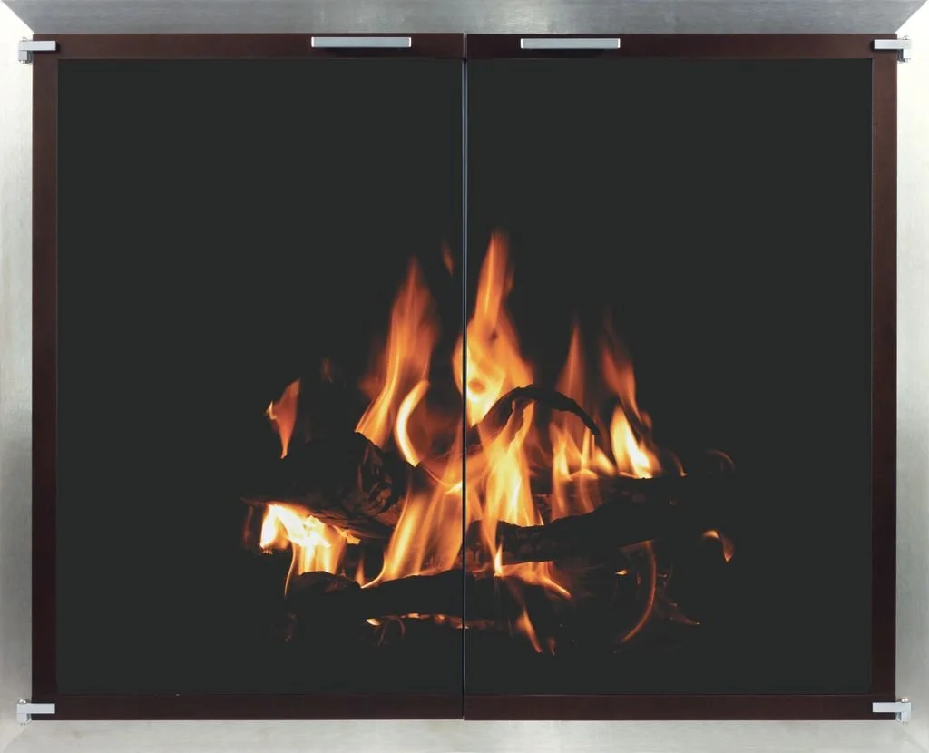 Fire burning on logs inside a black fireplace with a dark background.