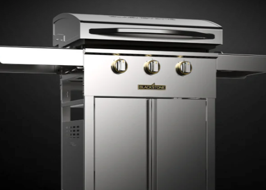 A stainless steel Blackstone outdoor grill with three control knobs and a side shelf.