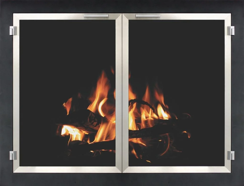 A fireplace with a glass door showing a burning fire inside with orange flames and charred logs.