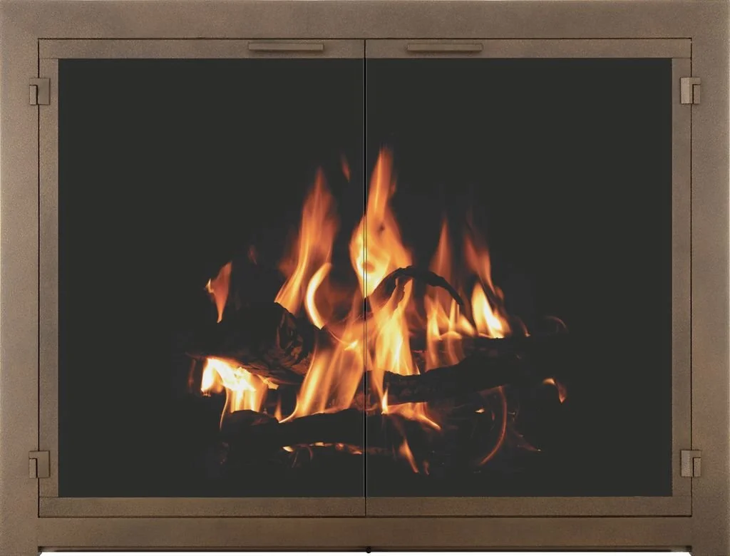 A fireplace with a fire burning and flames rising behind a glass screen.