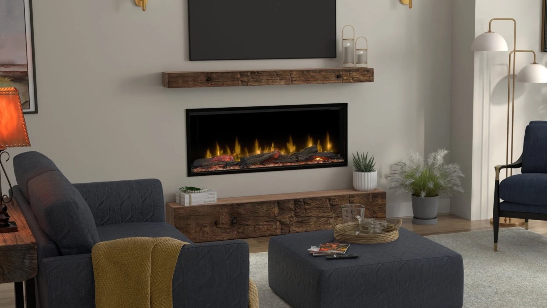 Living room with a modern electric fireplace, dark blue couch with a yellow throw, wooden coffee table with magazines, gray ottoman with drinks, and plants near a white wall with pictures and a wooden mantel.