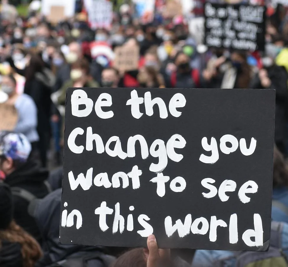 be the change you want to see in this world protest sign held up in crowd