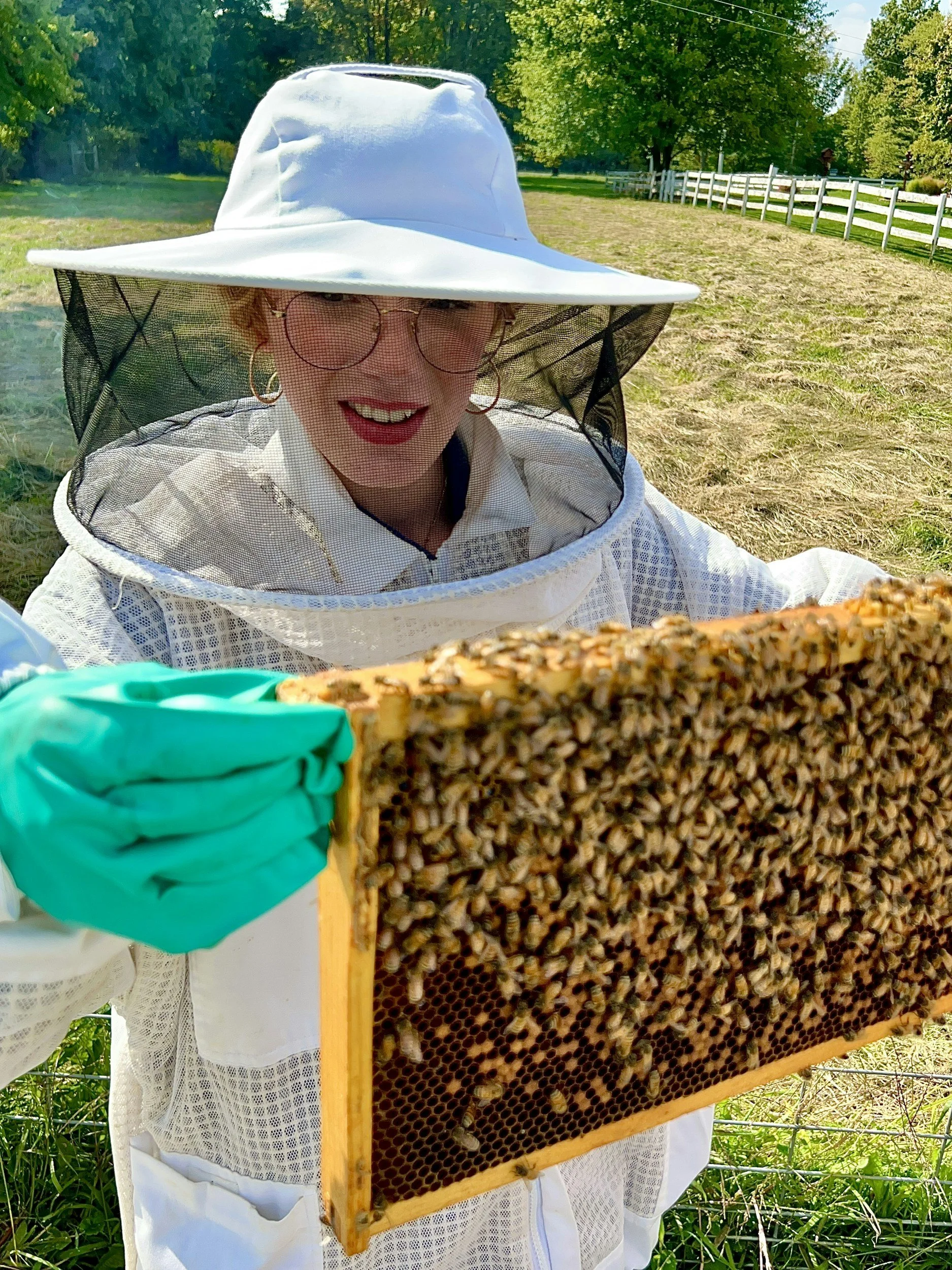 A beekeeper holding a hive in a backyard.