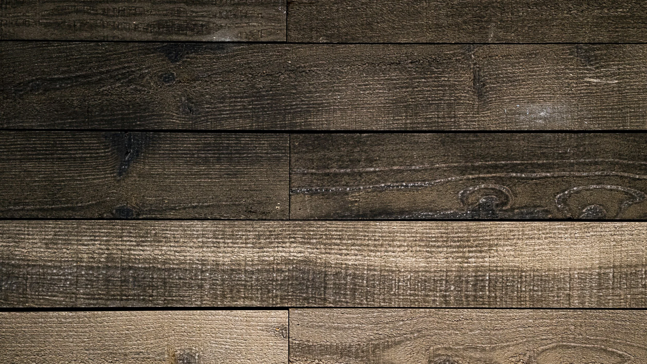 Close-up of a wooden surface made of horizontal planks with different shades of brown.