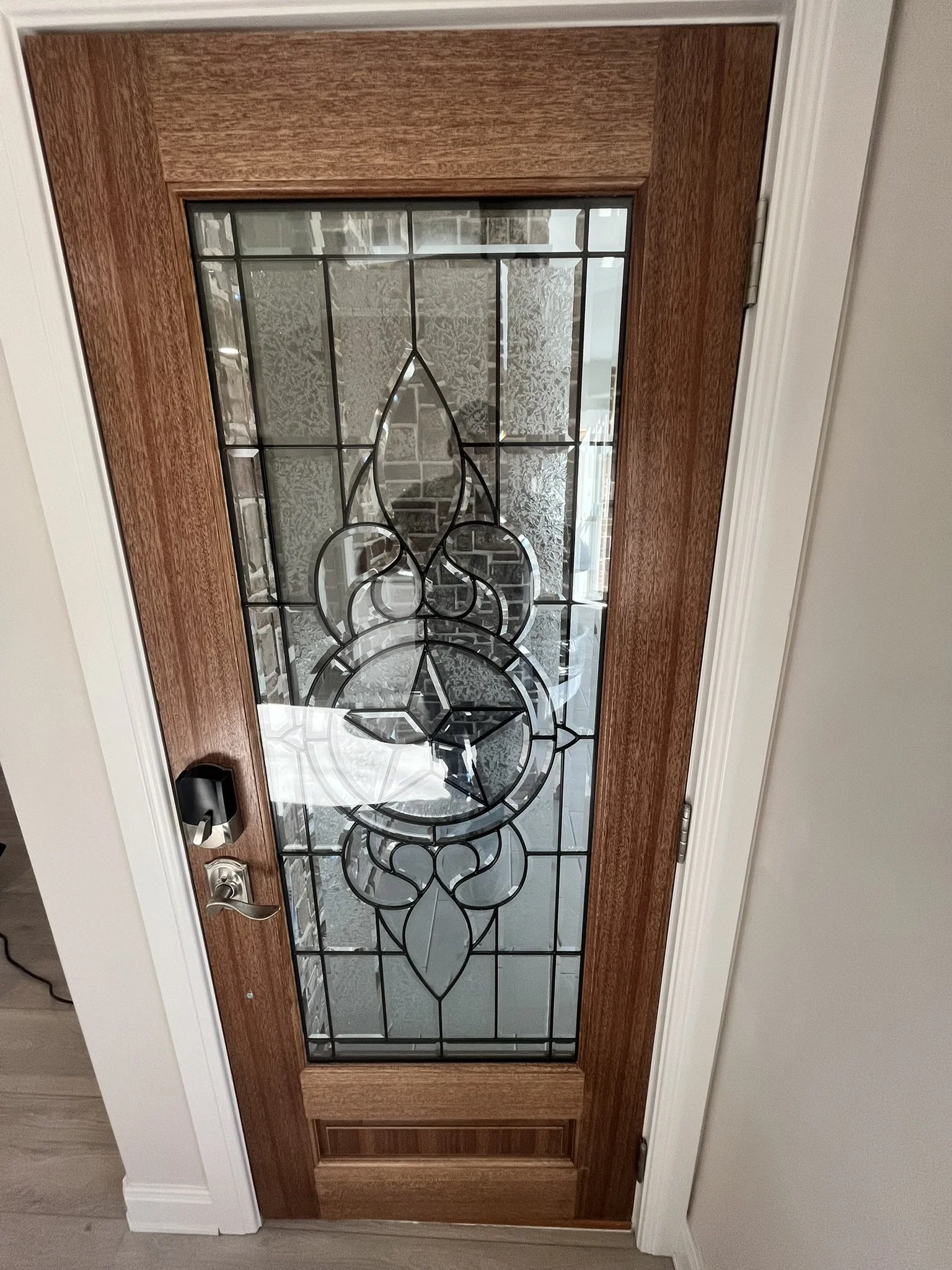 Front door with wooden frame and decorative glass panel