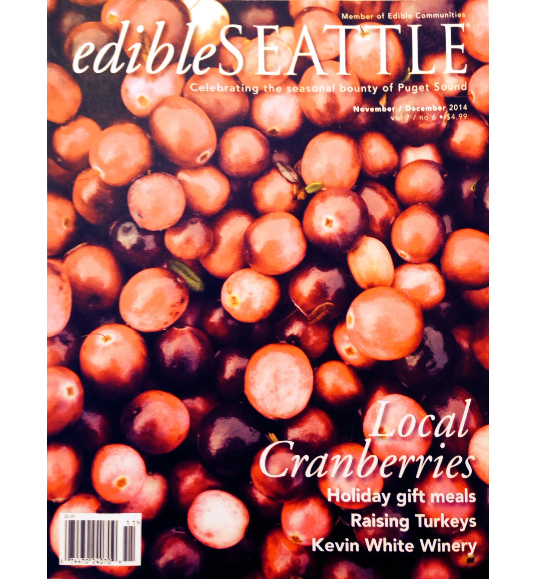 Cover of a magazine titled 'eddieSEATTLE', featuring a background of cranberries, with the subtitle 'Celebrating the seasonal bounty of Puget Sound'. The issue is from November / December 2014, volume 7, number 6, priced at $4.99. The magazine includes articles on holiday gift meals, raising turkeys, and features Kevin White Winery.
