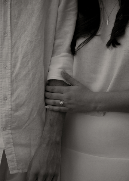 A couple holding hands, with the woman's hand displaying an engagement ring