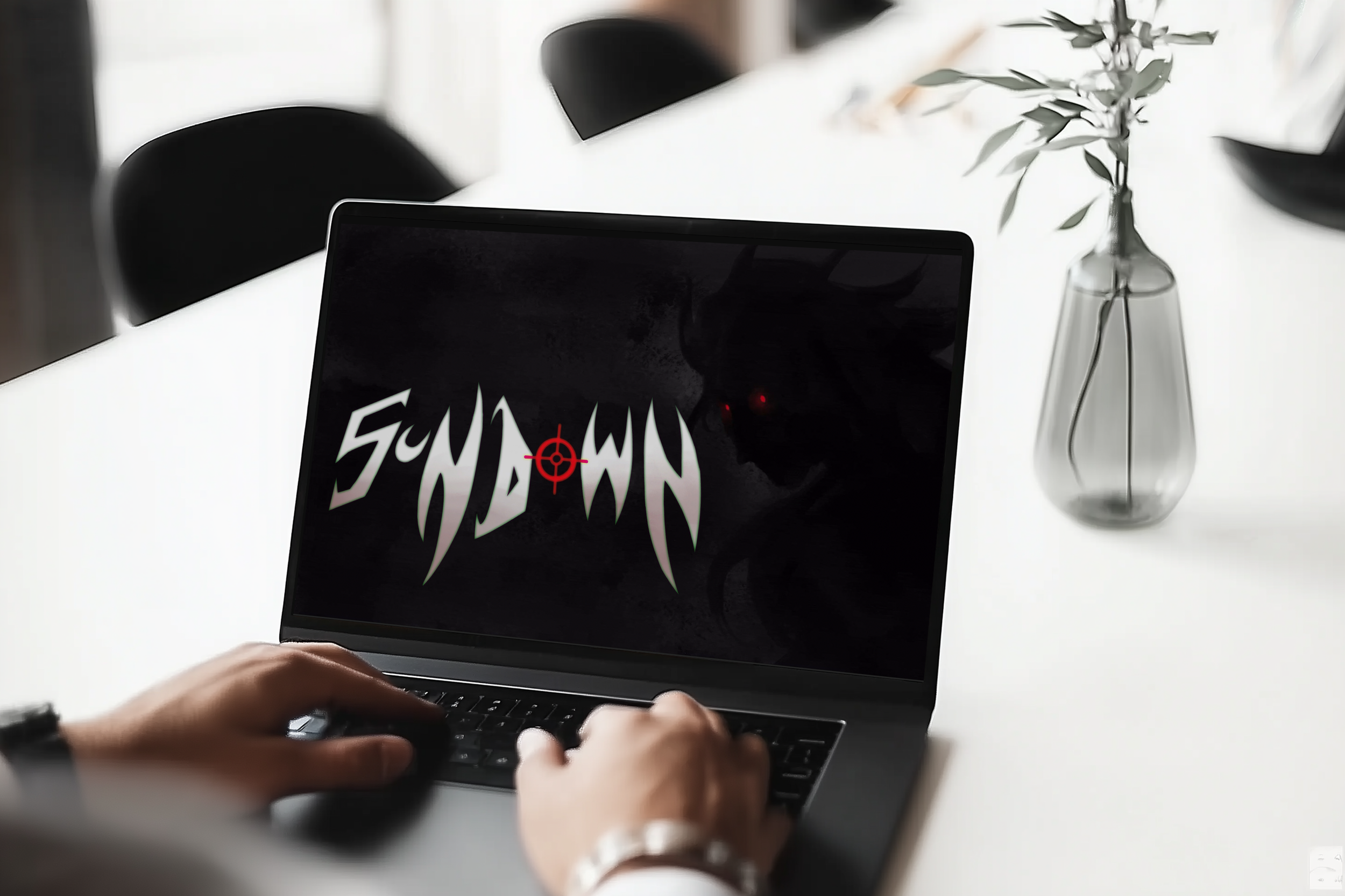Person typing on a laptop with a screen displaying text that reads "SCREAM" and a red targeting circle. In the background, there is a glass vase with a leafy plant on a white table.