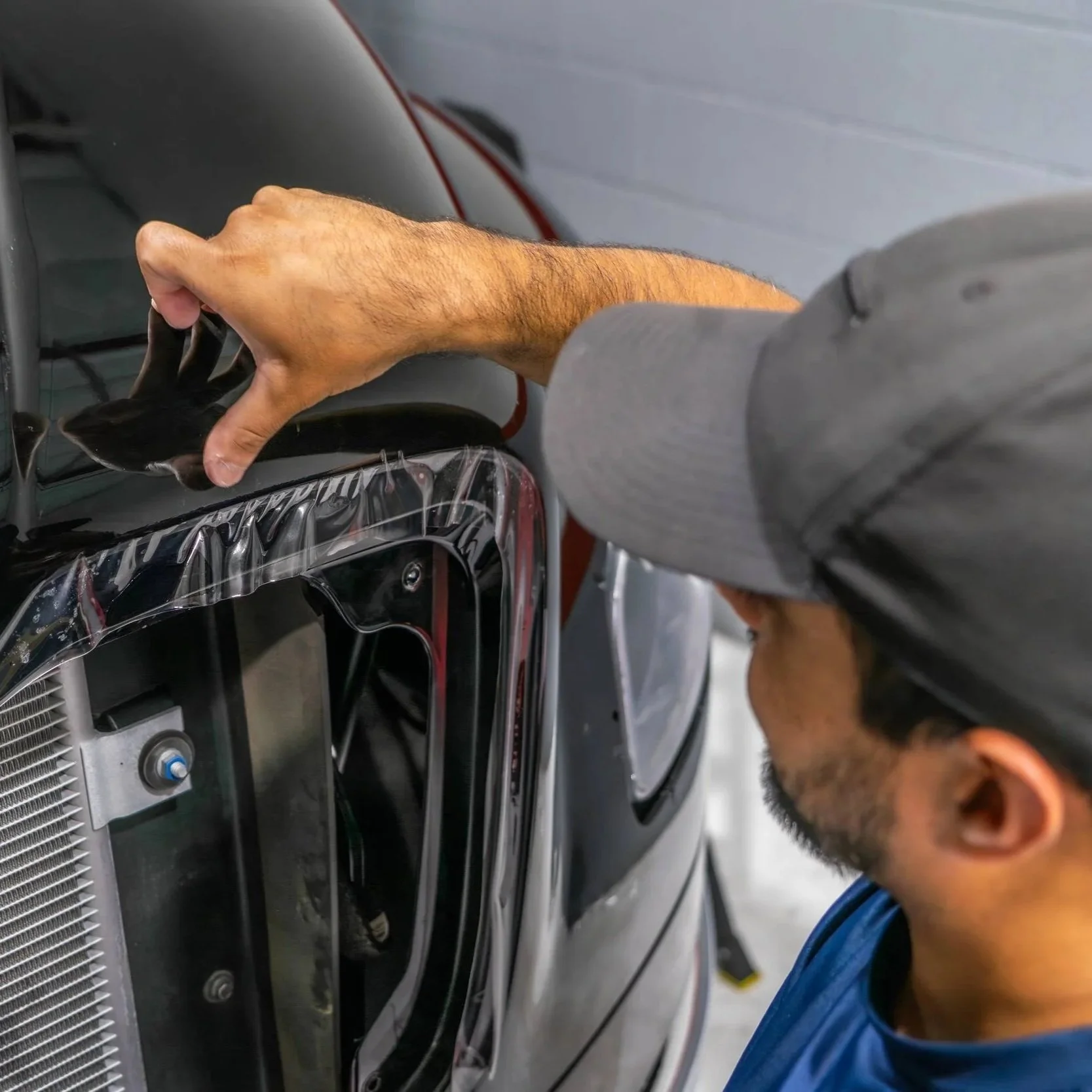 Professional detailing a fleet vehicle’s exterior panel and trim, cleaning dust and protecting surfaces under Scottsdale’s harsh driving conditions.
