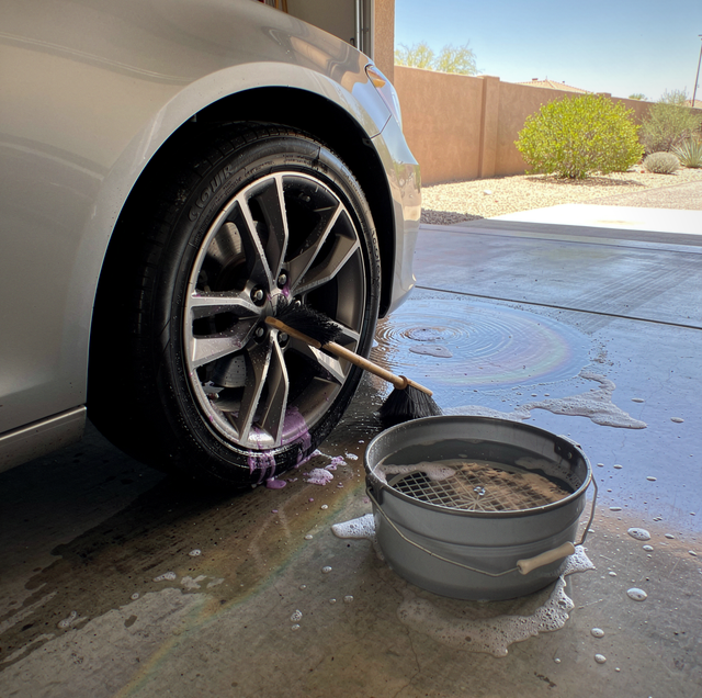 foam-covered wheel with tar and brake dust being sprayed
