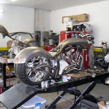 A custom motorcycle on a workbench in a garage or workshop