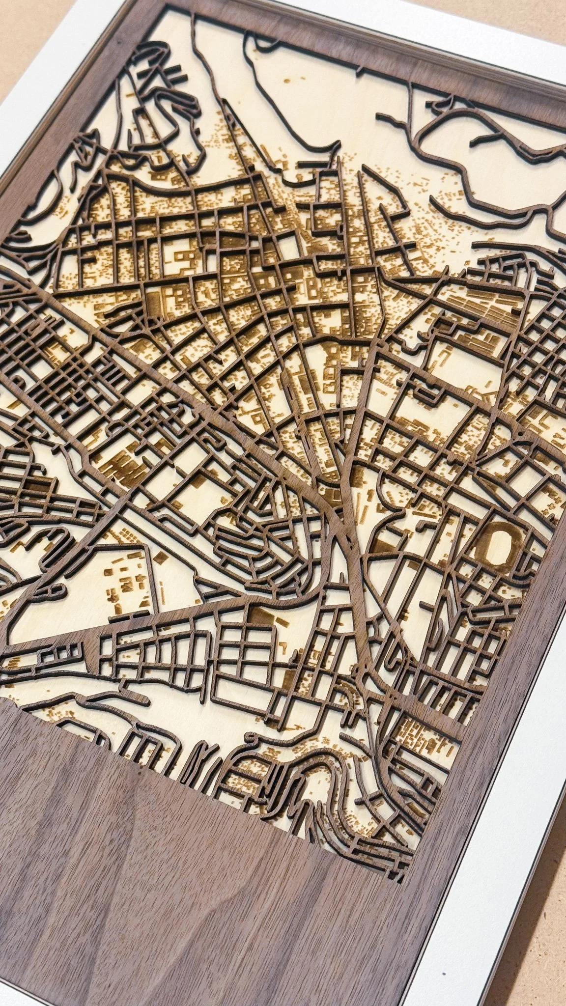 Wooden framed map with intricate street layouts and waterways.