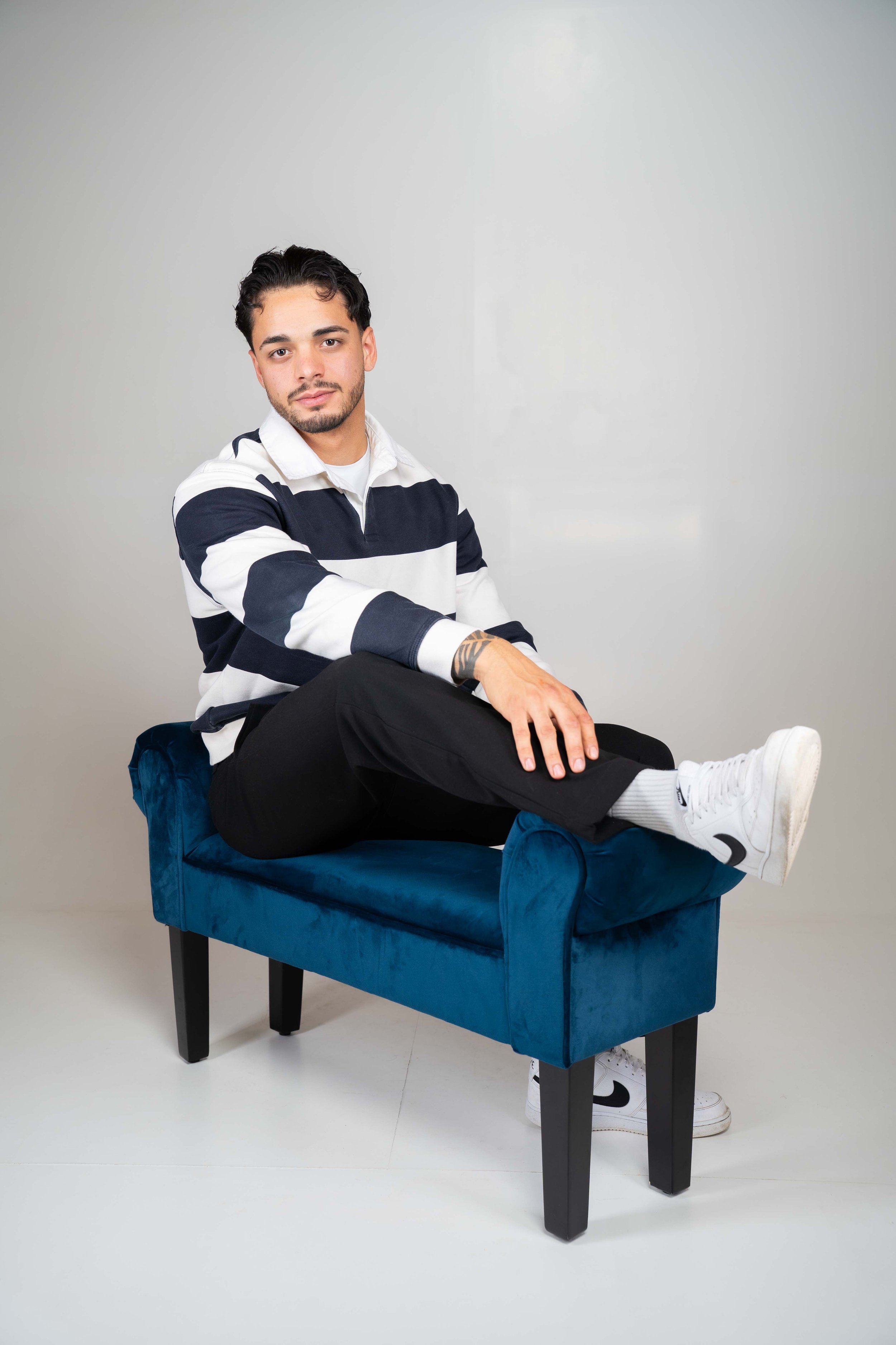 Model sitzt im Studio während eines Fotoshootings für Sedcard und Social Media Content