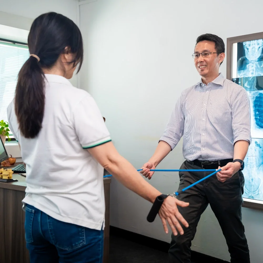 Patient performing resistance band exercise guided by chiropractor