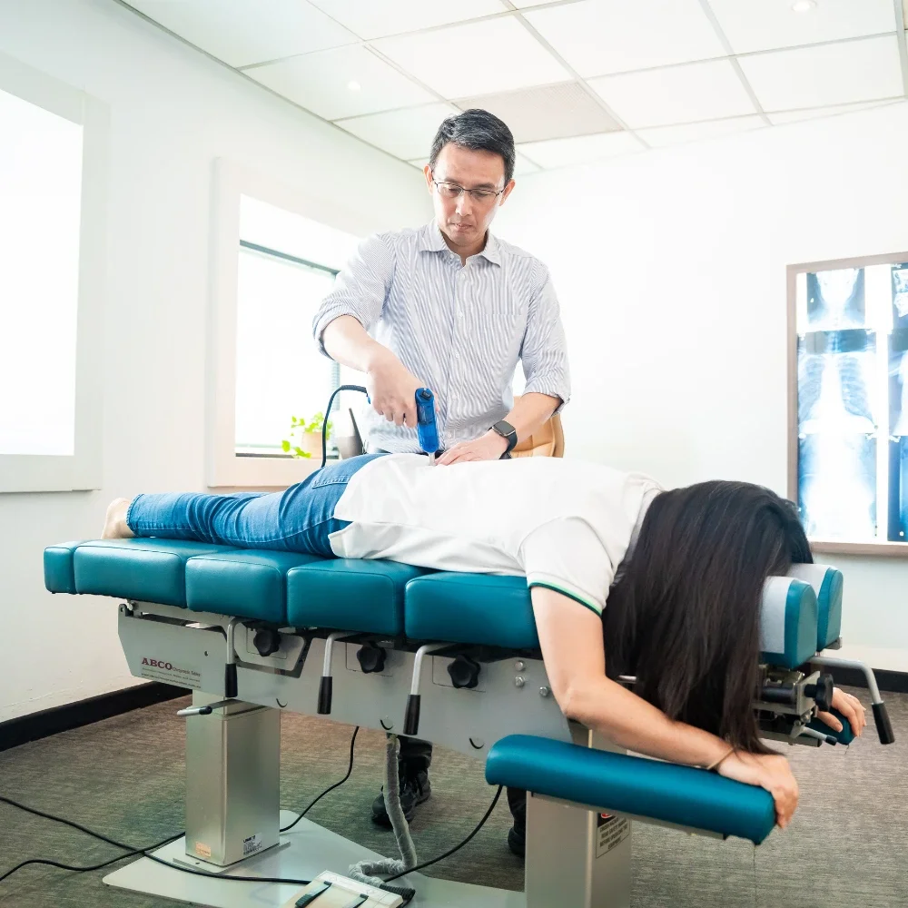 Chiropractic treatment session with spinal adjustment on patient in Singapore clinic
