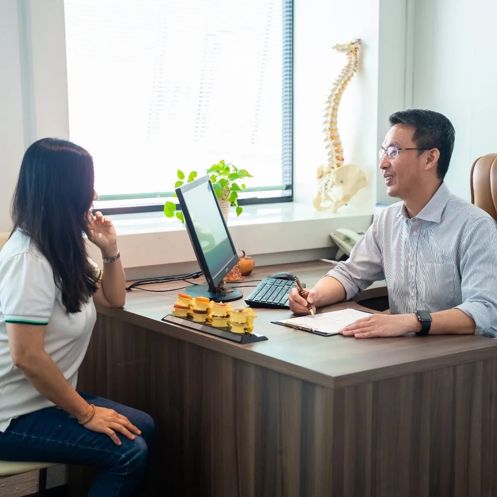 Chiropractor consulting with patient during initial assessment in clinic