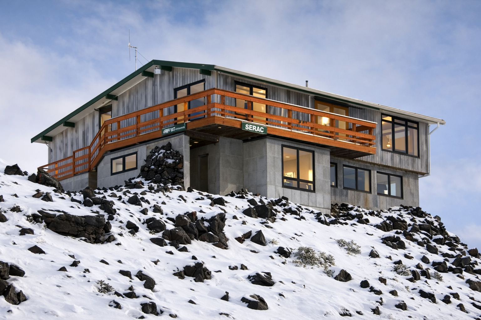 A modern house built on a snowy slope, featuring a wooden balcony and large windows, with a sign that reads 'SERAC'.