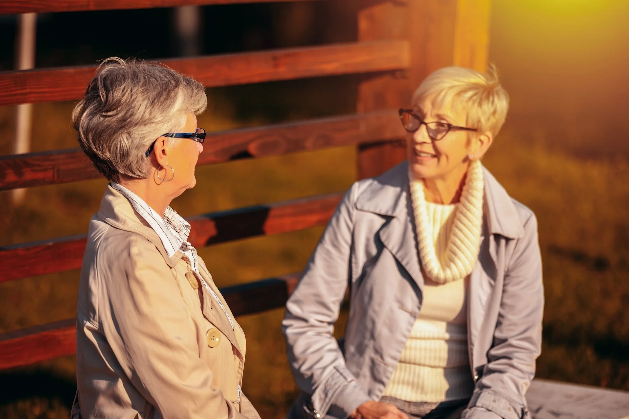 Two women in conversation sitting on a park bench