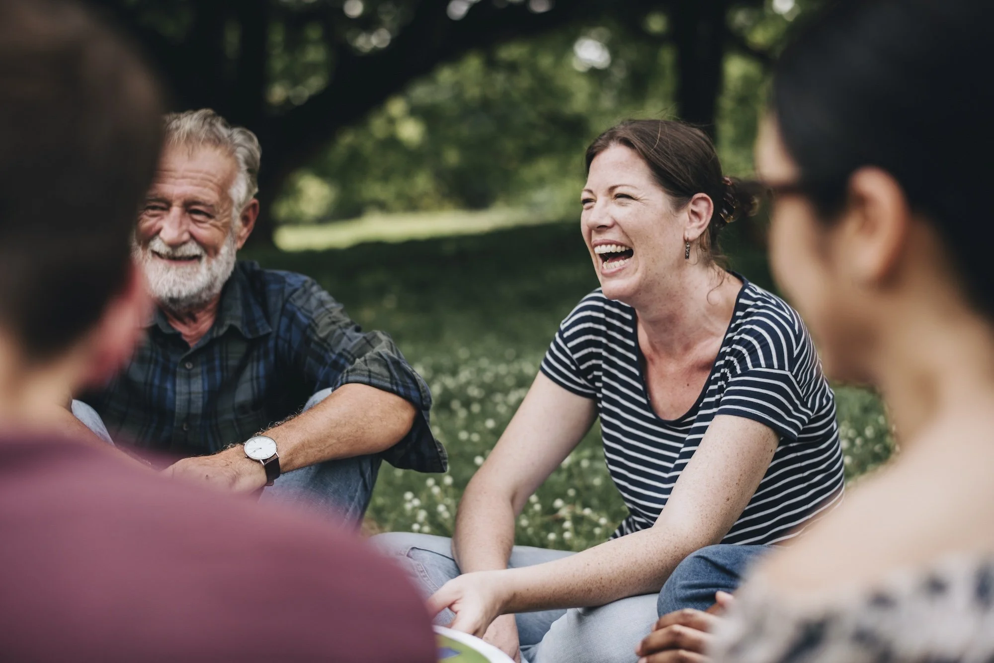 Woman laughing with group in park in nature