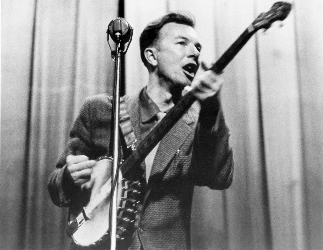 Pete Seeger urging the audience not to jump on the Vienna straw chairs. In the Fifties the Nylon reinforced weave that is used in Folk chairs was not yet used.