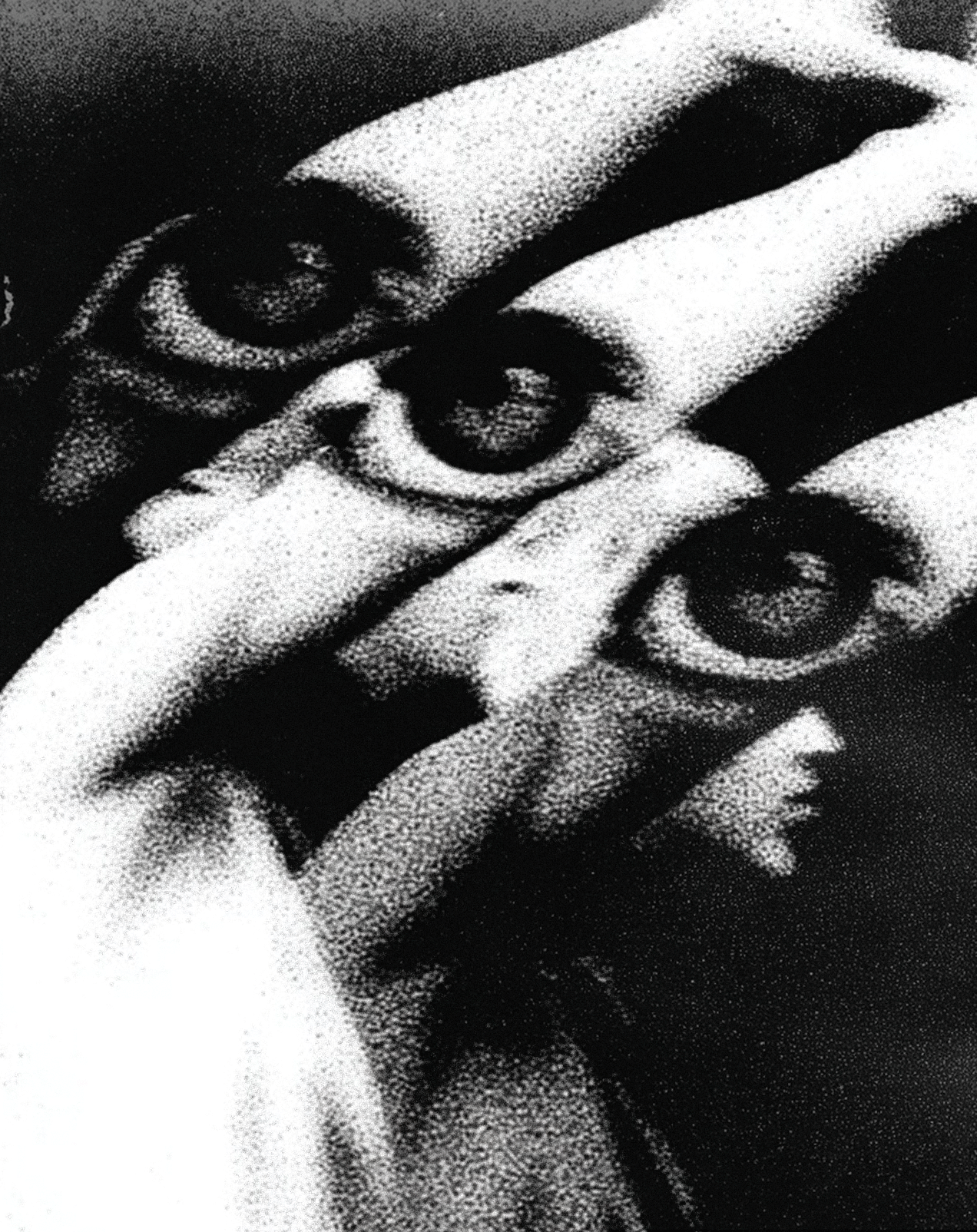 Black and white image of a person’s hand holding three small roll-up banners or posters with eye illustrations on them.