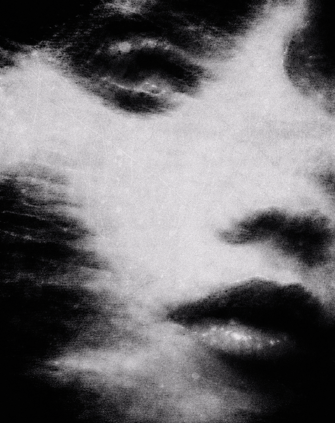 Close-up of a person's face in black and white, showing only closed eyes and lips with blurred effect.