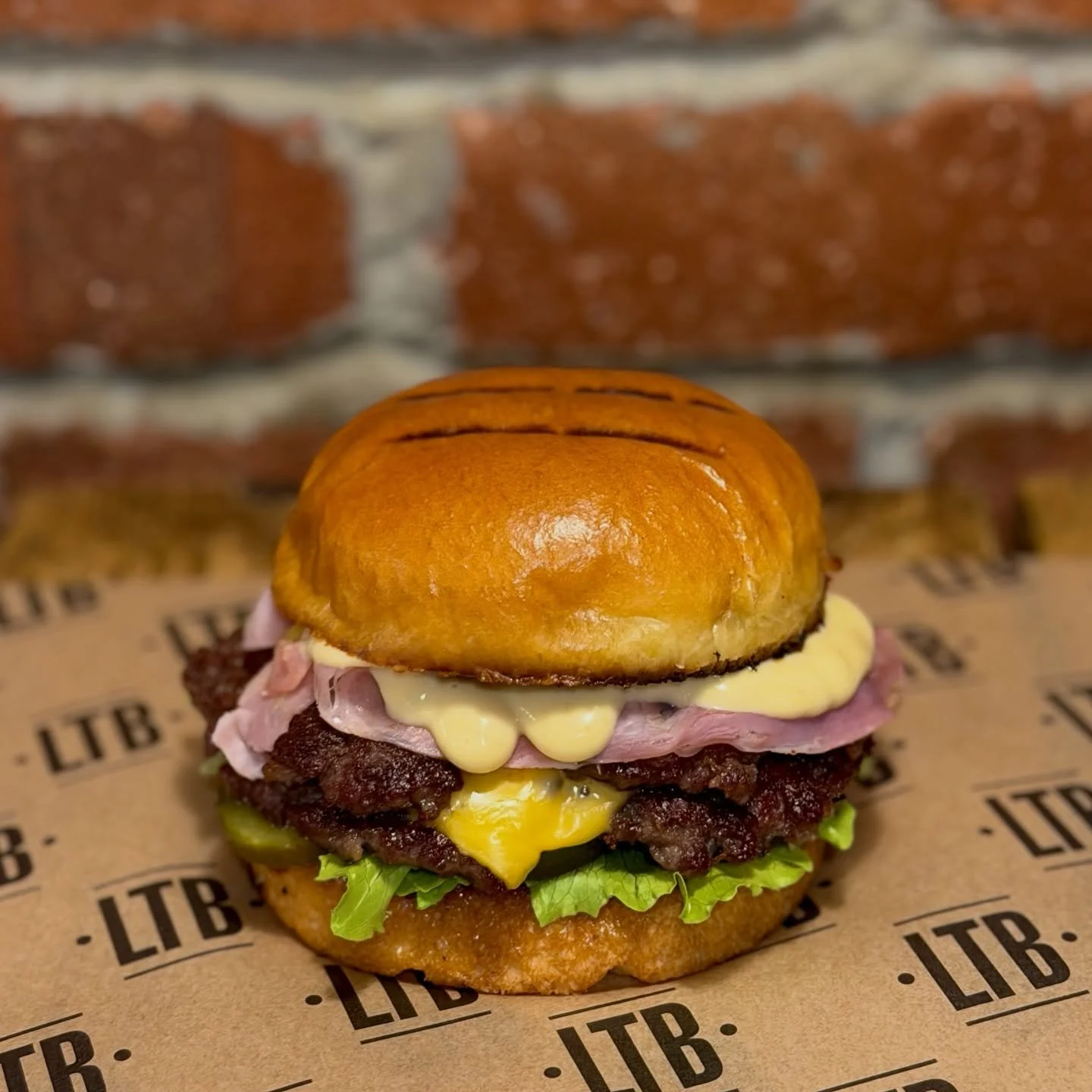 The Royal Stack 🍯🍔

Sweet, smoky, and packed with punch - every bite tells a story.
Crispy toasted bun with rich brown honey butter, red onion marmalade, lettuce, gherkins, double smash patties, melty cheese, ham, tangy Dijon, and all the crunch yo