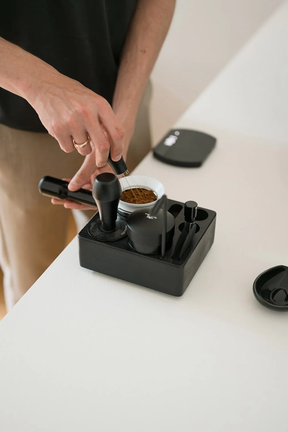 Präzise Vorbereitung eines Espresso-Shots durch die gleichmäßige Verteilung des Kaffeemehls mit einem WDT-Tool.
