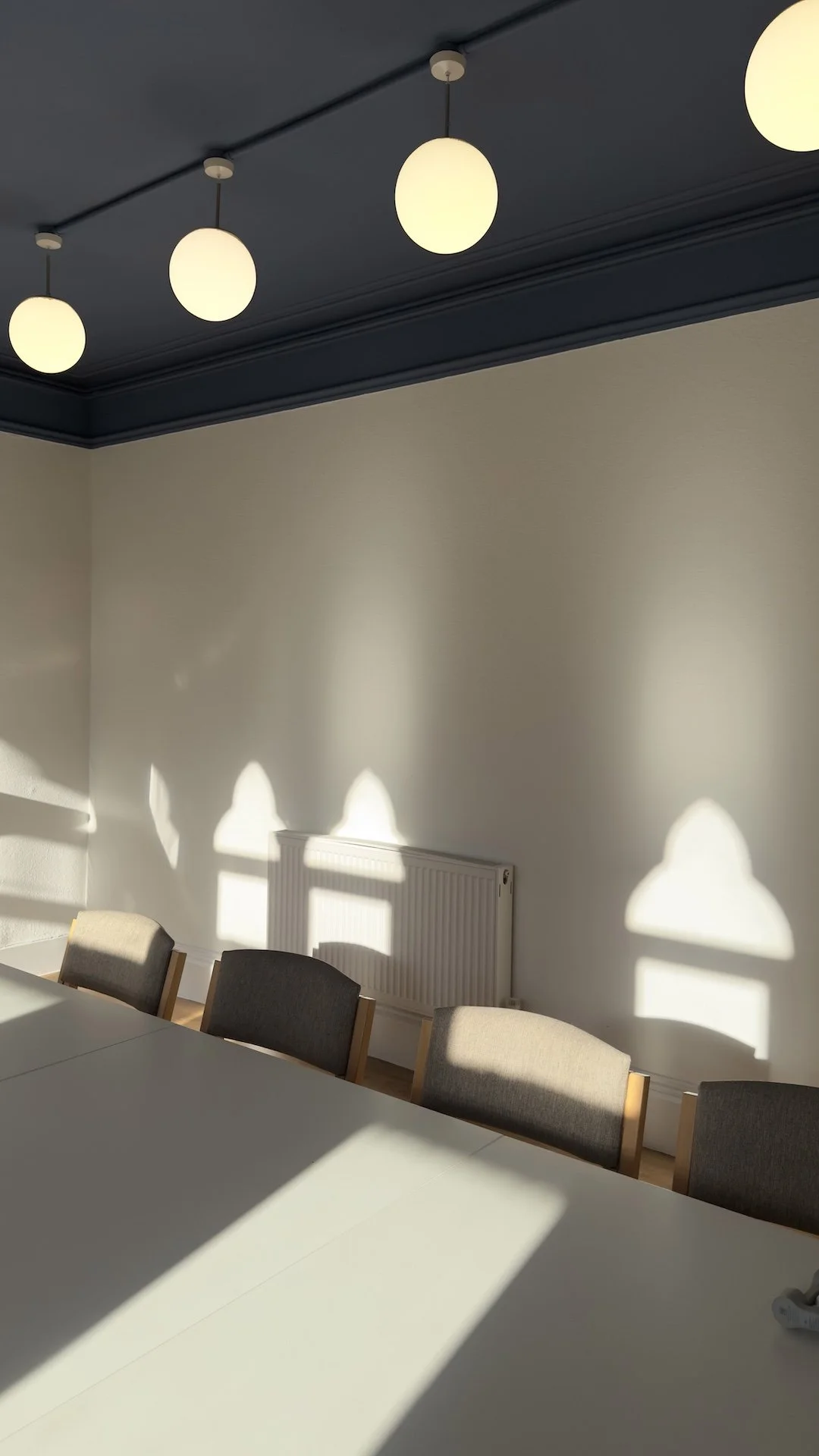  Contemporary communal meeting room with globe pendant lighting and warm evening sunlight by Studio EWW 