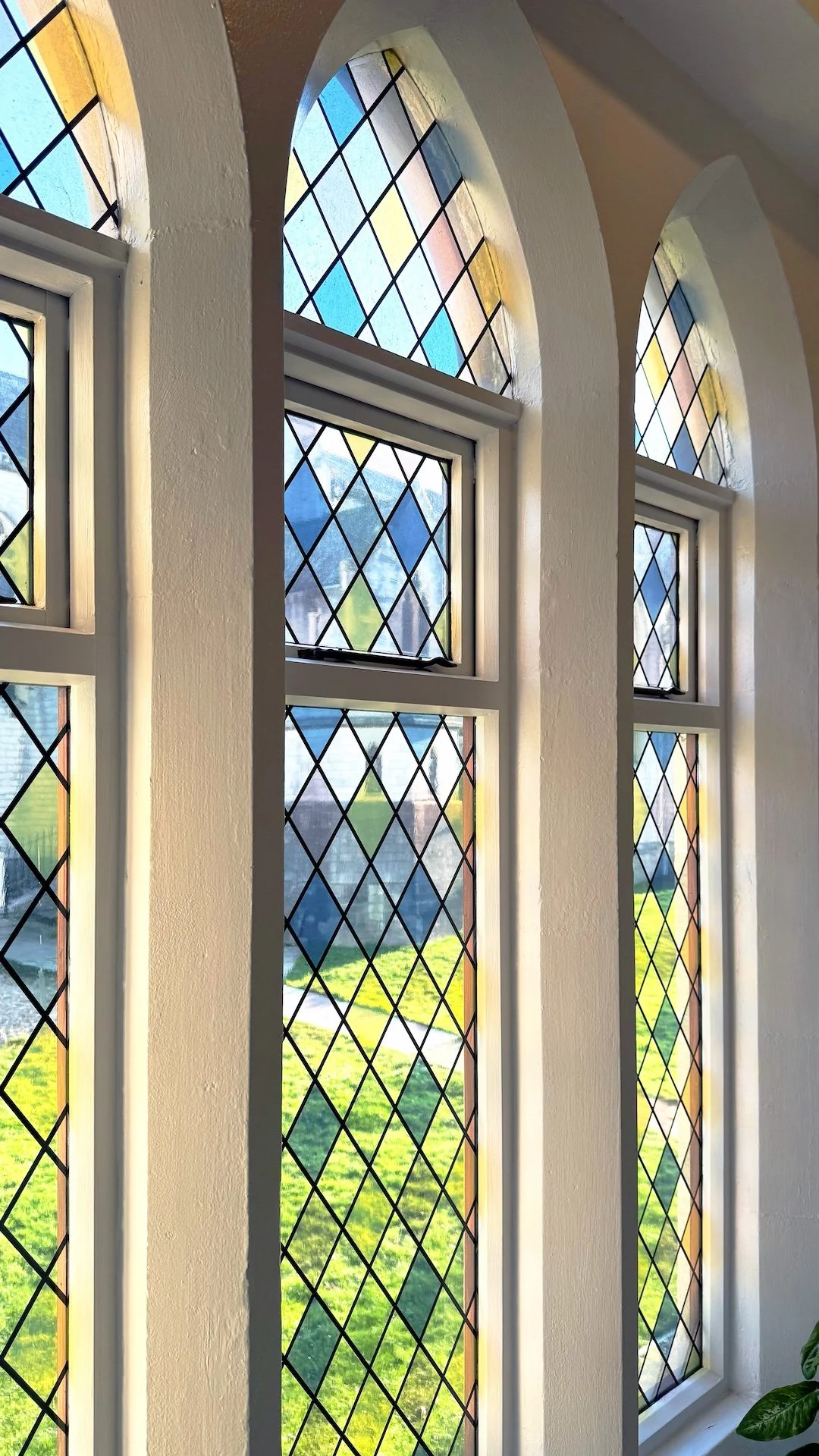  Gothic inspired stained glass windows with colourful natural light in restored heritage interior by Studio EWW 