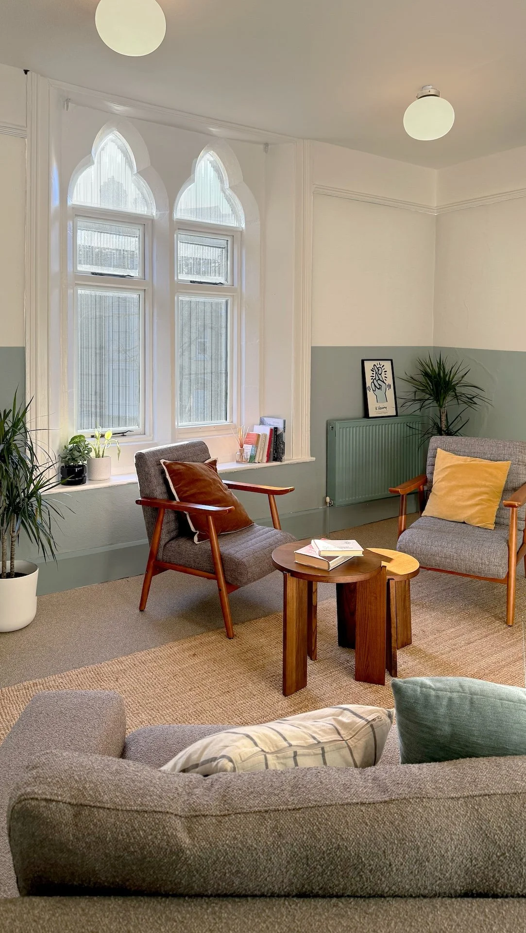 Calm communal lounge with mid-century furniture and restored gothic windows by Studio EWW 