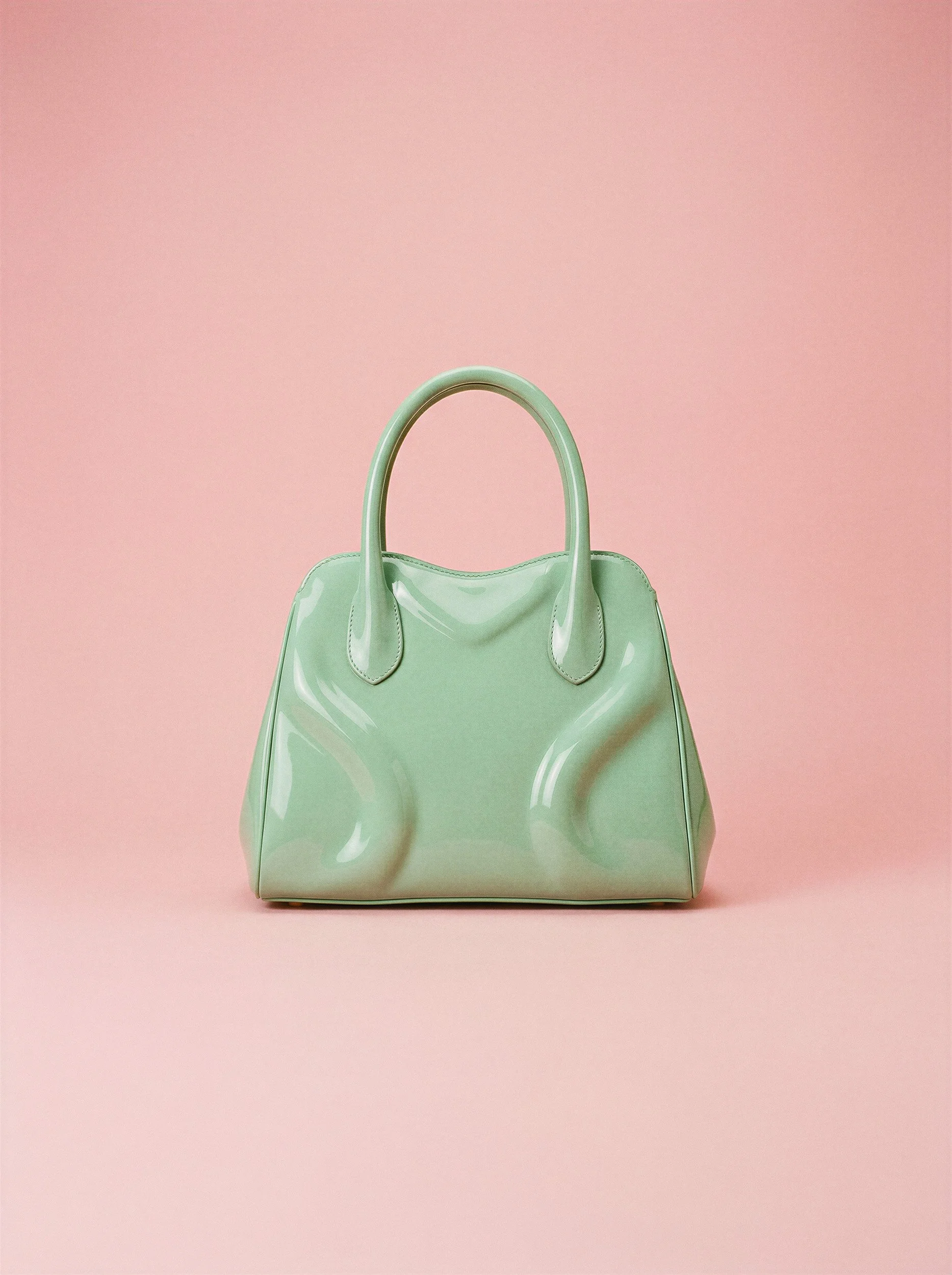 "Commercial product shot of a mint green glossy handbag against a solid pink background. Highlighting the material accuracy and reflections produced by The Raw Lab's advanced AI visual engine."