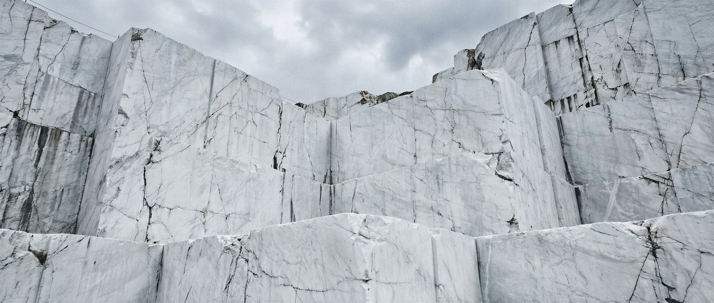 "A desolate and imposing white marble quarry landscape. A synthetic environment created for high-fashion campaign production, eliminating the need for complex on-site logistics."