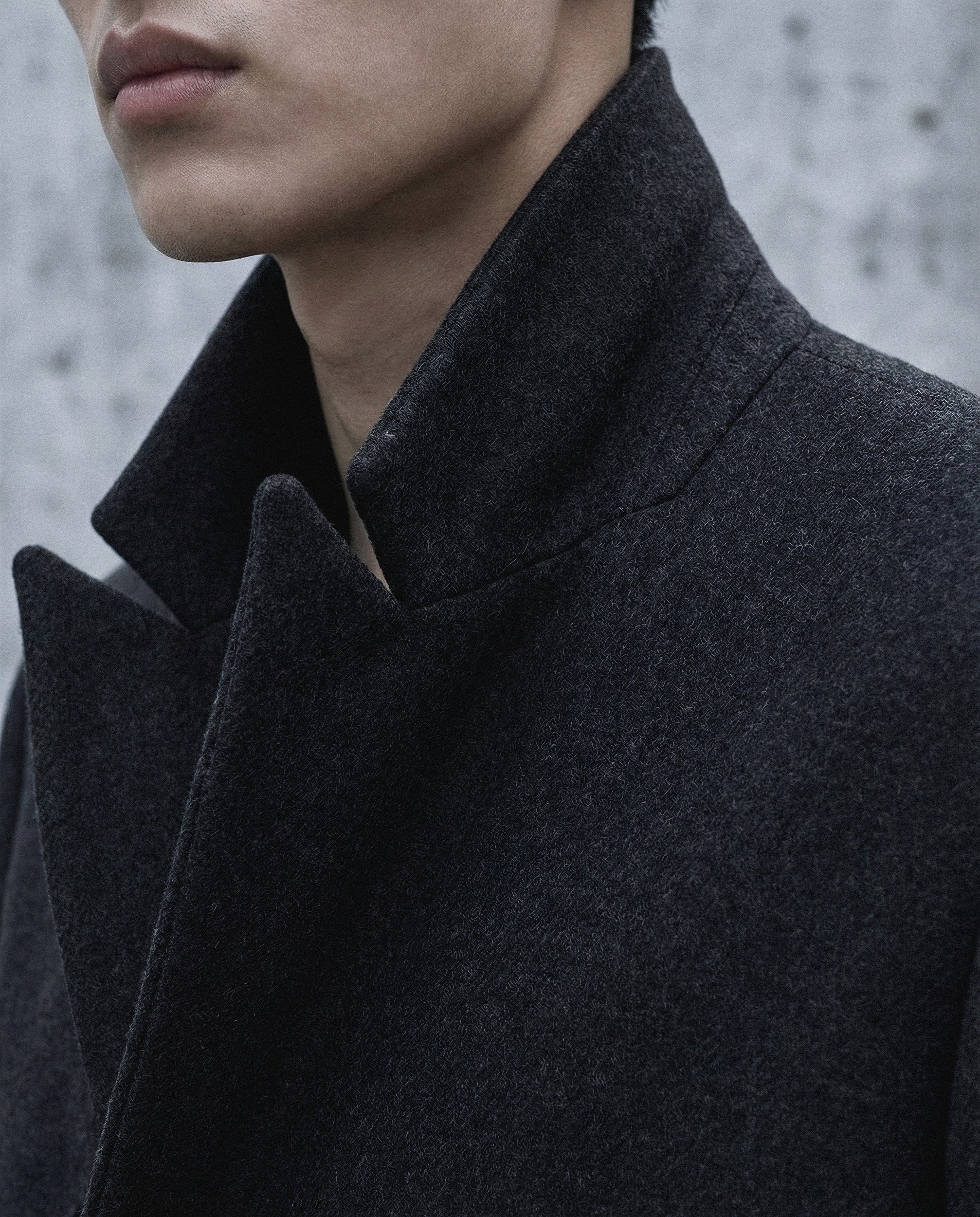 "Extreme close-up of a coat lapel focusing on the heavy wool grain and precise tailoring. This image highlights the hyper-realistic material fidelity achieved by The Raw Lab visual engine."