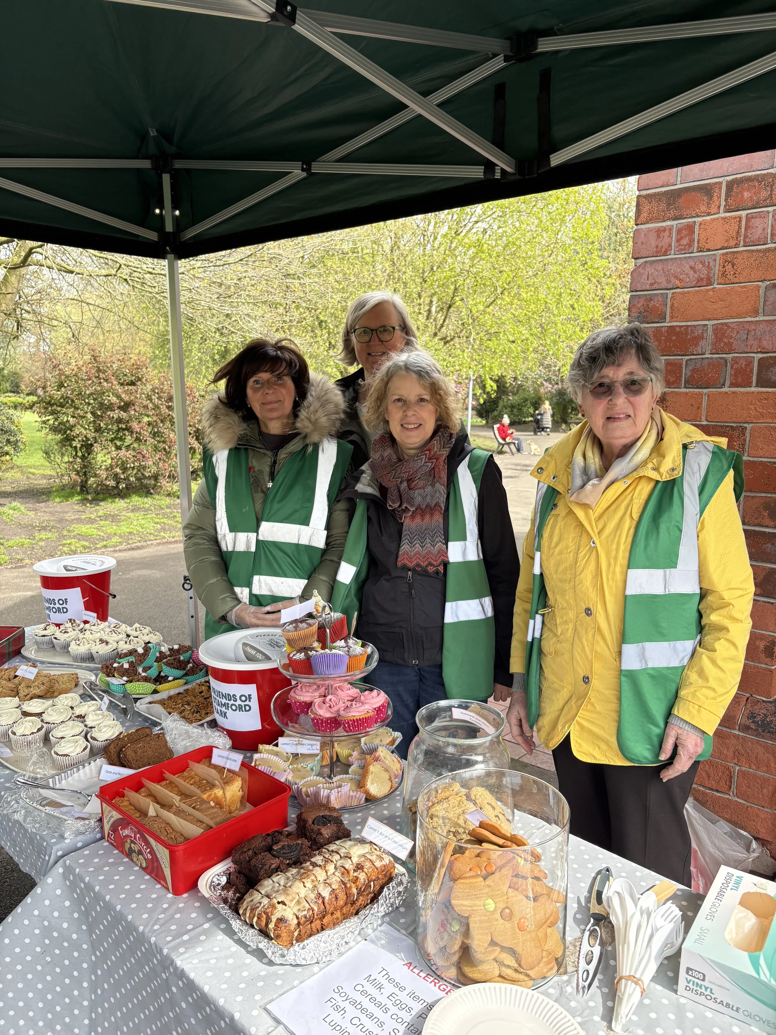 a group of volunteers, including Natalie Shalom (Conservative Councillor for Hale Ward), selling cakes in the park