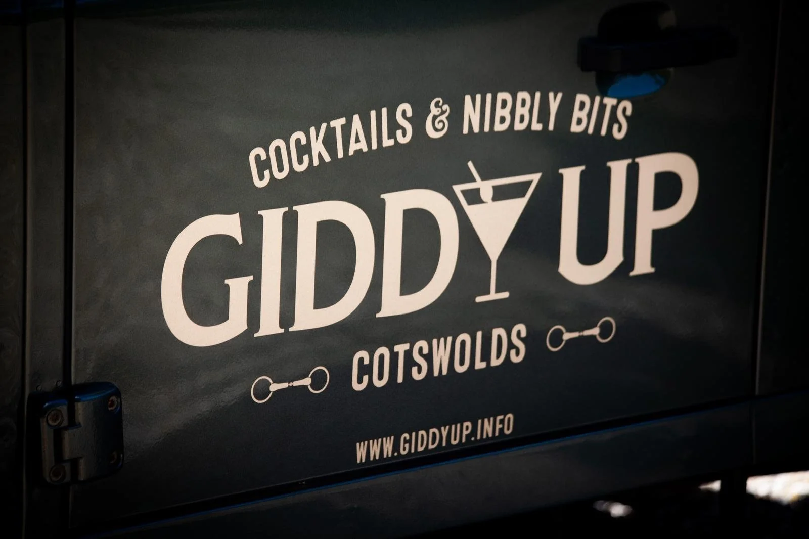 Giddy Up sign advertising cocktails and nibbly bits, located in Cotswolds, with website URL www.giddyup.info