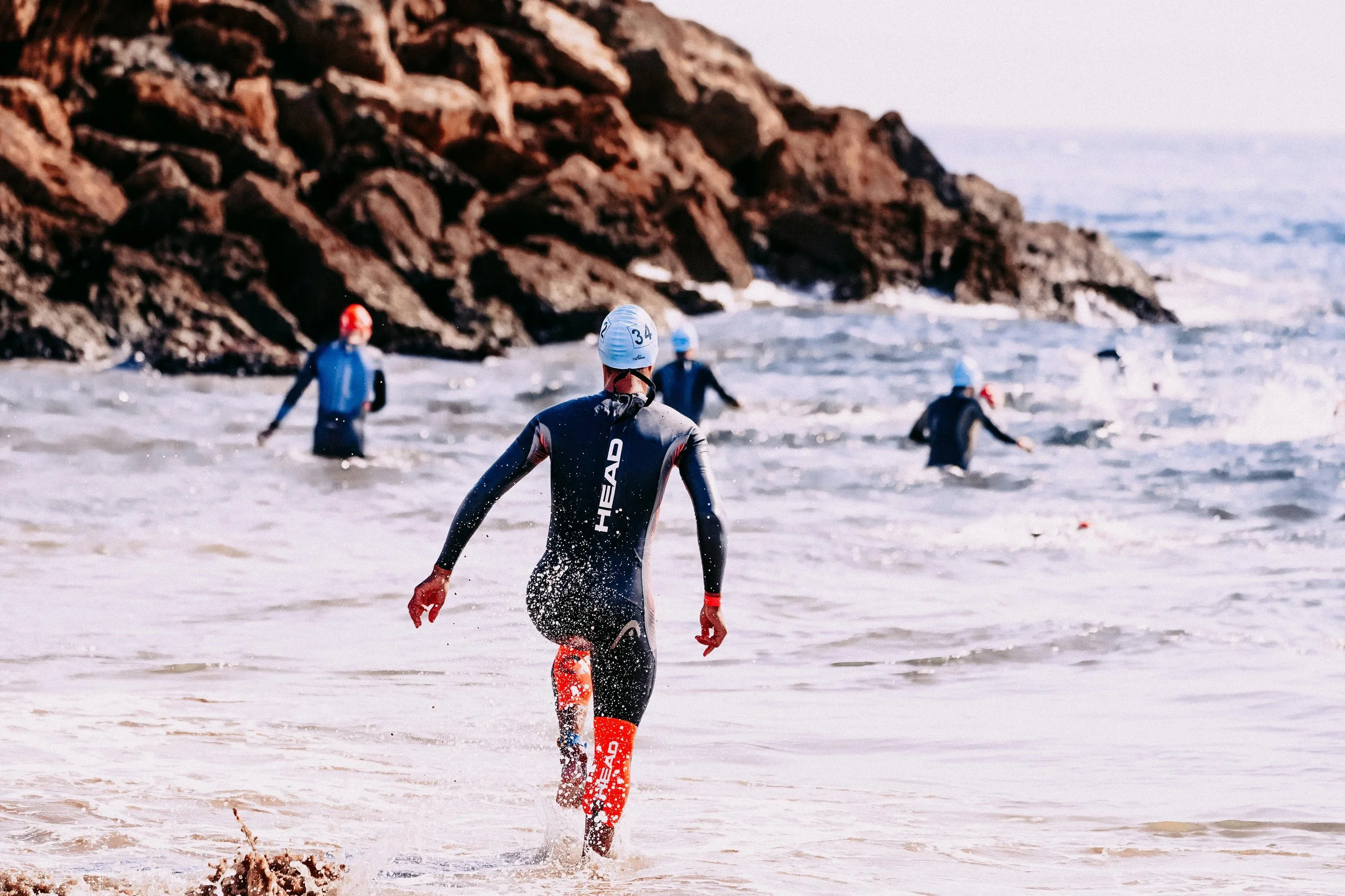Female triathlete entering water at the start of a triathlon