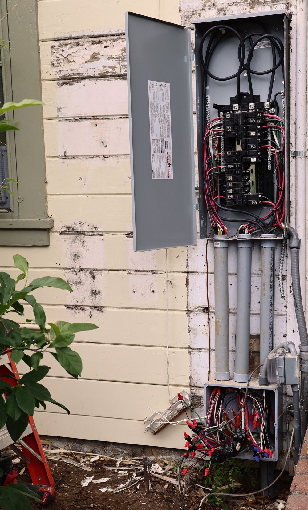 The original Siemens electrical panel at Court & Current Estate, with its cover open and wiring exposed