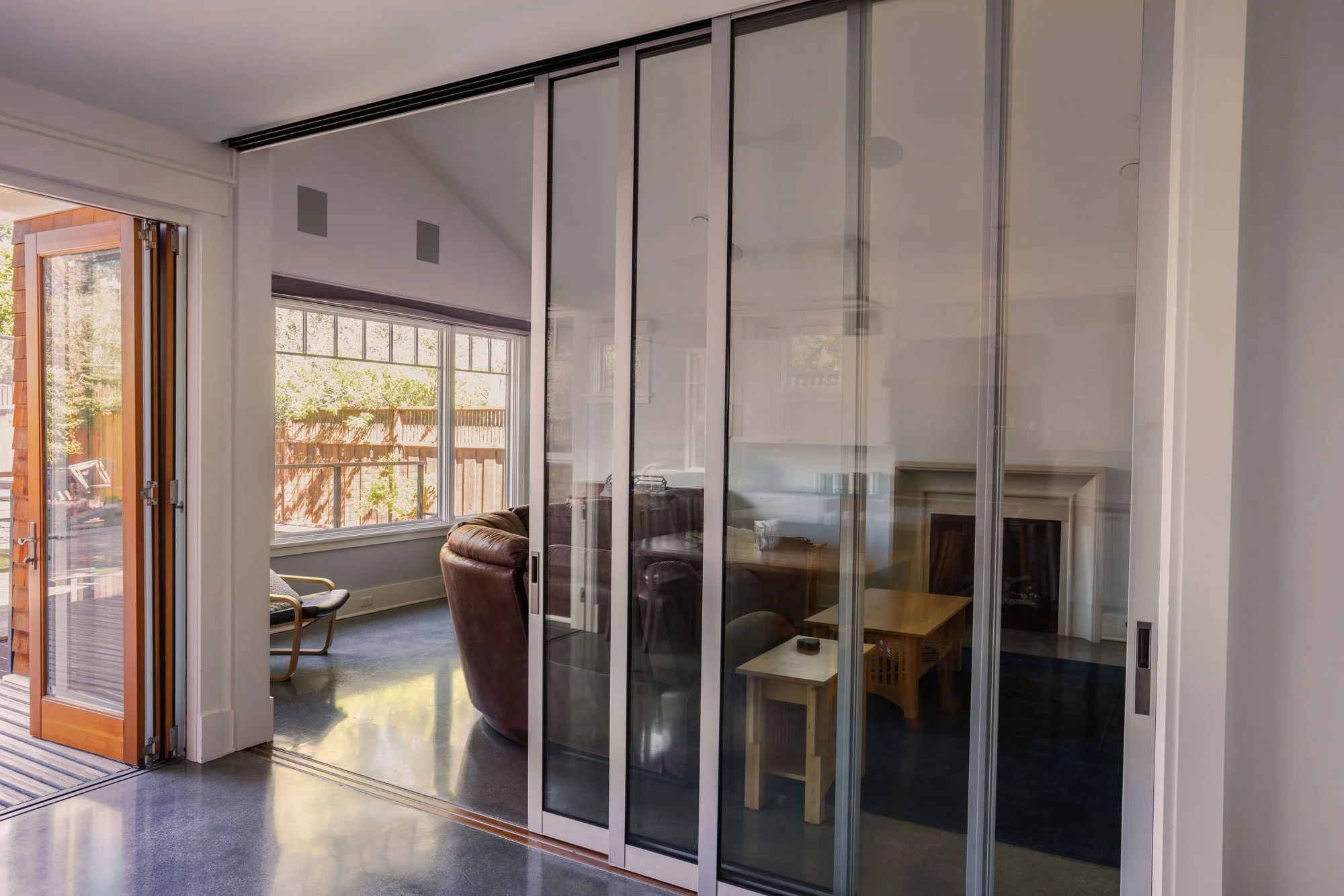 Custom accordion glass door connecting an outdoor deck.and family room.