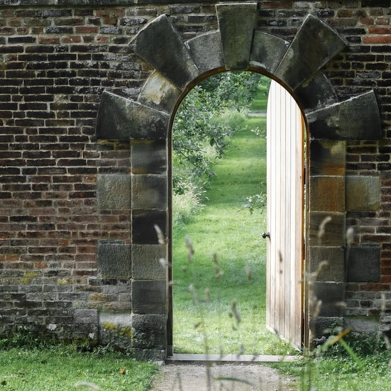 Arched doorway leading to traditional orchard garden