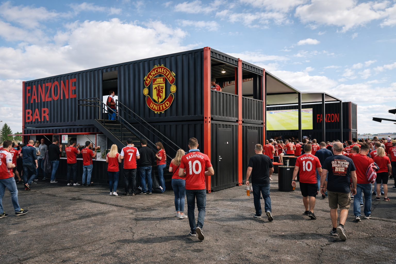 Crowd of Manchester United fans at a fan zone bar, with a container building featuring the Manchester United logo and a large screen showing a sports game.