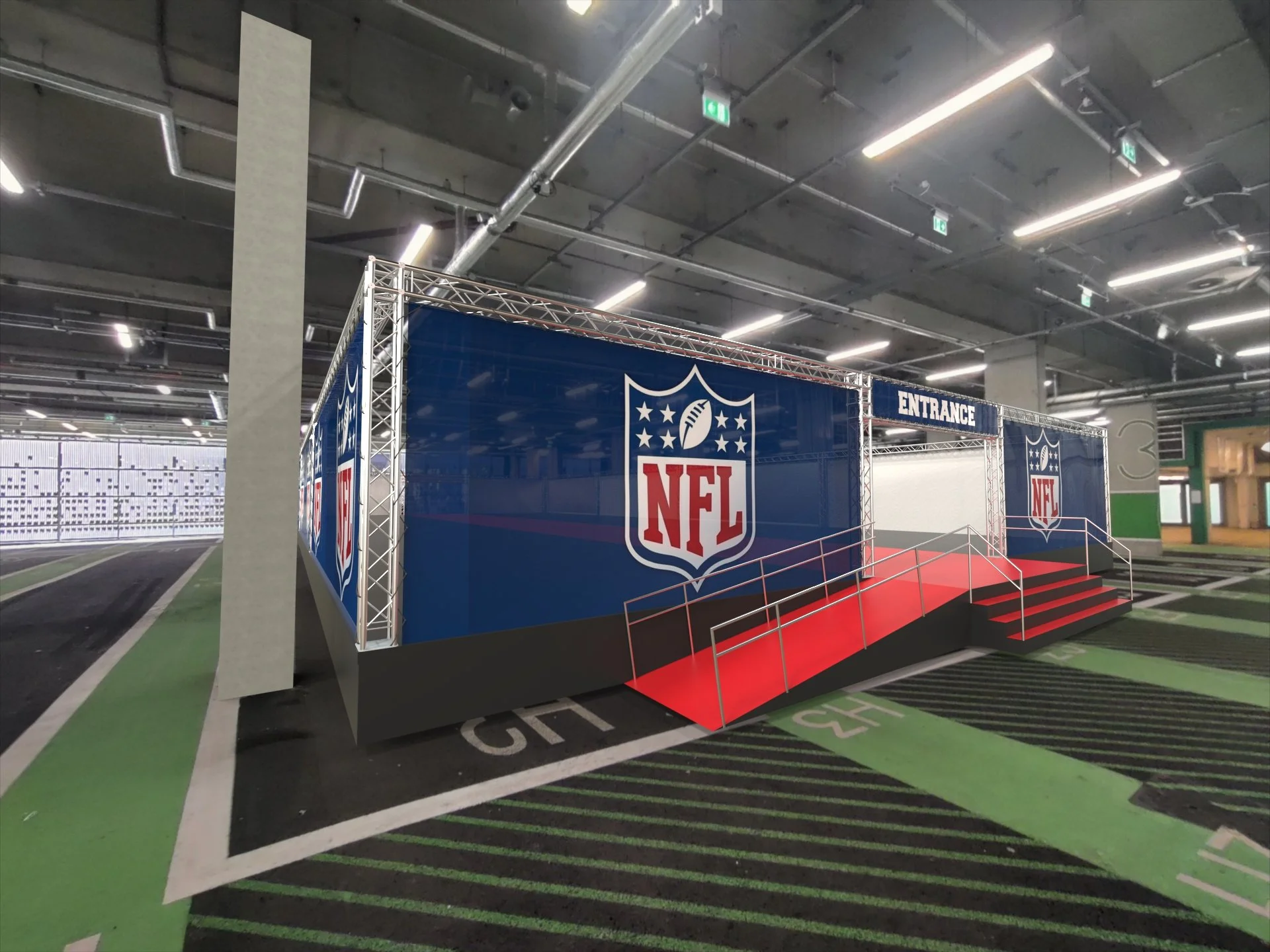 Indoor NFL event setup with a blue backdrop displaying the NFL logo, a sign that reads 'ENTRANCE,' and stairs leading up to a white screen or stage area, surrounded by green and black flooring.