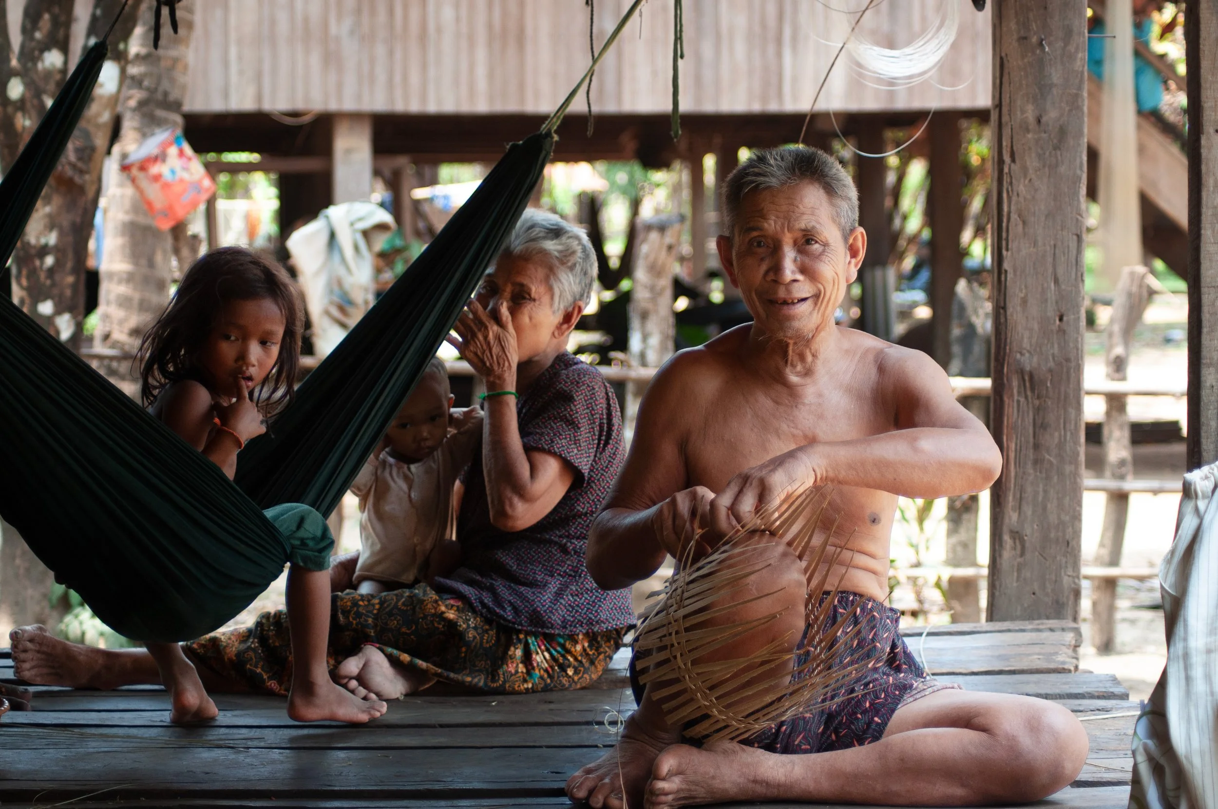A Laotian family sits in the shade under their home in Ratanakiri, northwestern Cambodia