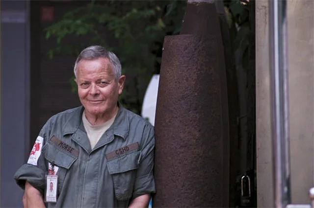 Bill Morse, in a Lon Nol Army uniform, leans against a recovered rocket outside the Landmine Museum in Siem Reap, Cambodia