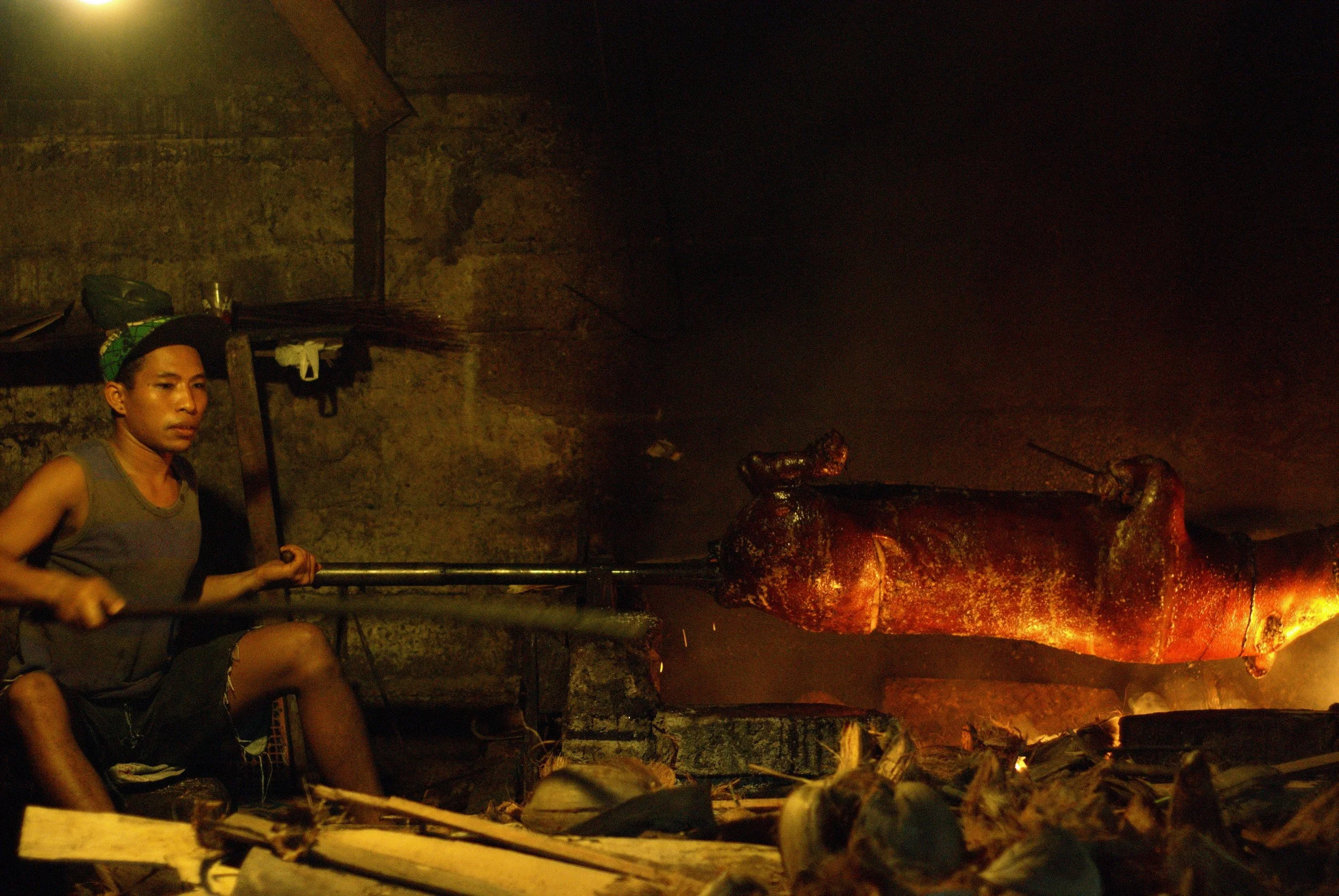 Babi guling roasts on an open fire at the family restaurant near Buduk, Bali